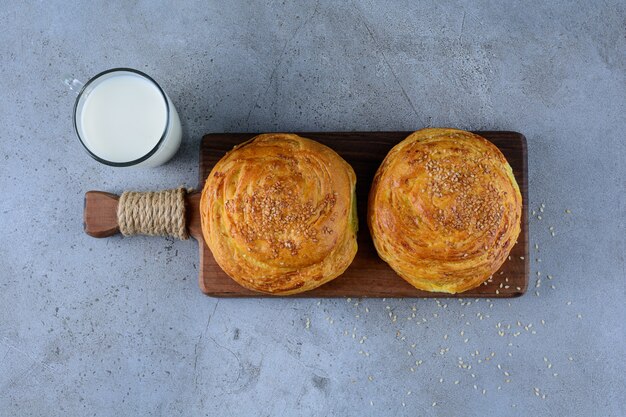 Ein Holzbrett des aserbaidschanischen nationalen Gebäcks mit einer Glasschale frischer Milch.