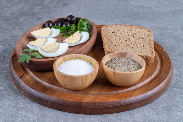 Ein Holzbrett mit gekochten Eiern und einer Scheibe Brot. Hochwertiges Foto