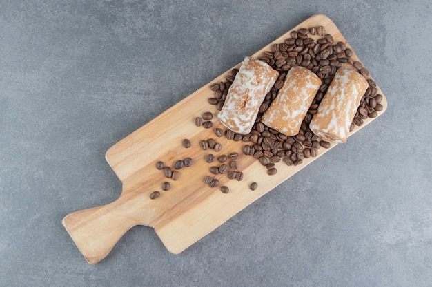 Ein Holzbrett mit süßem Lebkuchen und Kaffeebohnen