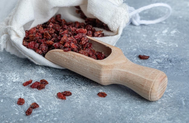 Ein holzlöffel voller getrockneter preiselbeeren.