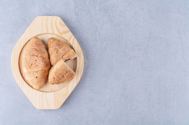 Ein Holzteller mit Croissants und leckerer Schokolade.