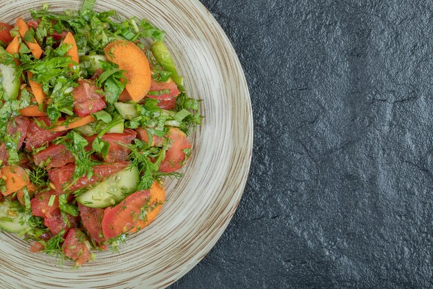 Ein Holzteller mit köstlichem Gemüsesalat.