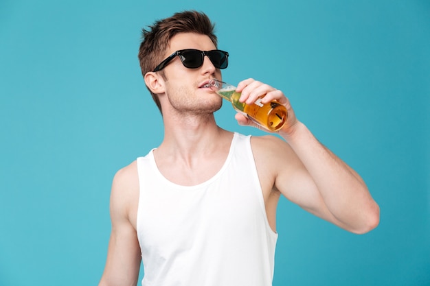 Ein hübscher junger Mann trinkt Bier