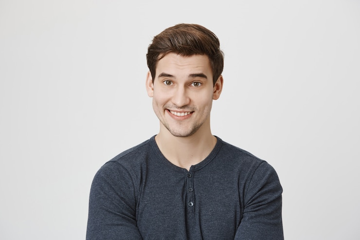 Kostenlose Foto ein hübscher, lächelnder mann, der mit unglauben schaut