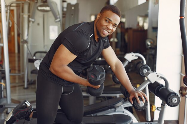 Ein hübscher schwarzer Mann ist in einem Fitnessstudio beschäftigt