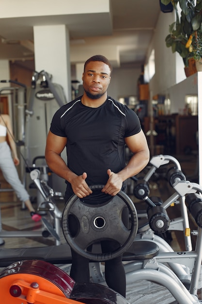 Ein hübscher schwarzer Mann ist in einem Fitnessstudio beschäftigt