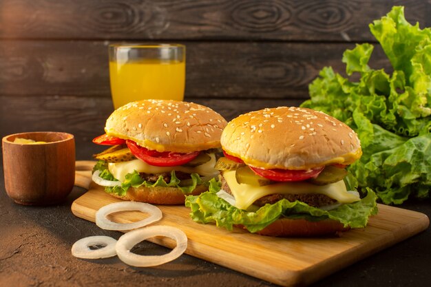 Ein Hühnchen-Burger von vorne mit Käsesaft und grünem Salat auf dem Holzschreibtisch und Sandwich-Fast-Food-Mahlzeit