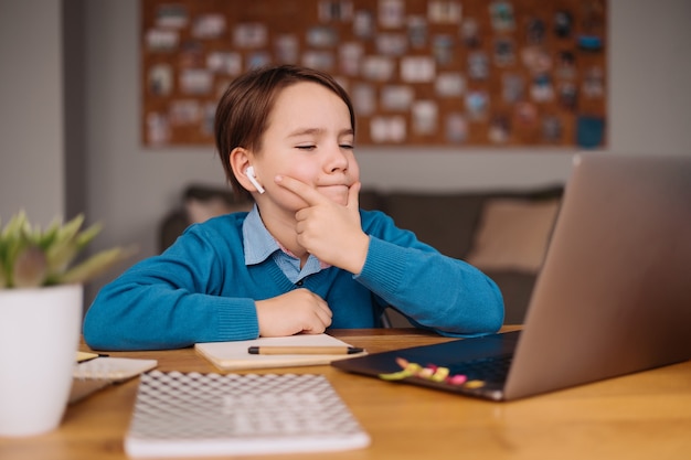 Ein jugendlicher Junge benutzt einen Laptop, um Online-Kurse zu machen
