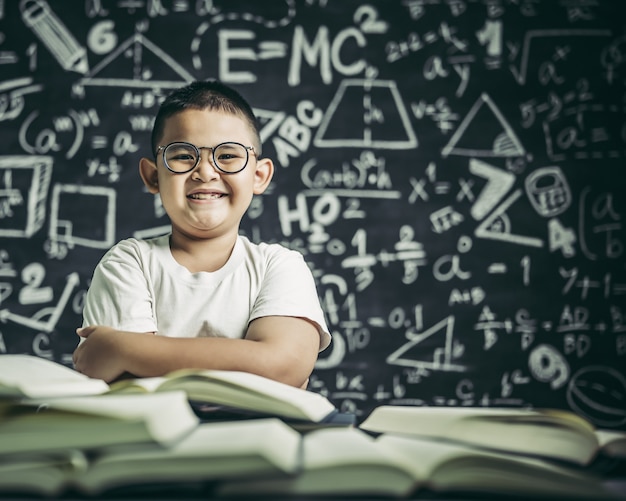 Ein Junge mit Brille sitzt im Klassenzimmer und liest