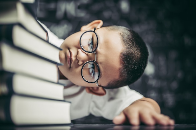 Ein Junge mit Brille sitzt im Klassenzimmer und zählt Bücher