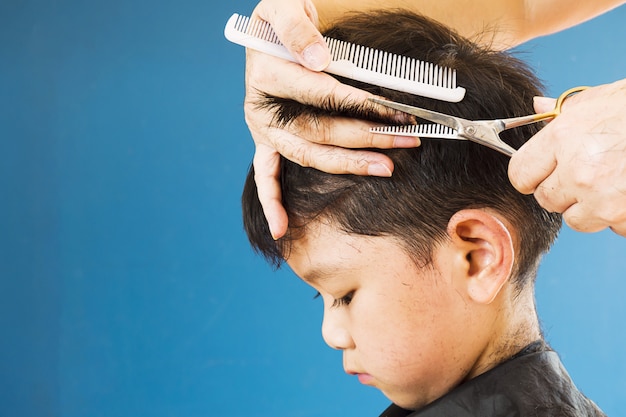 Ein Junge schneidet sein Haar von einem Friseur ab