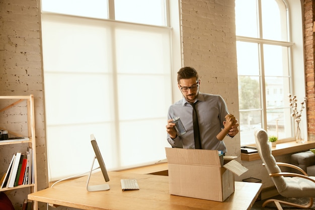 Ein junger Geschäftsmann, der im Büro umzieht