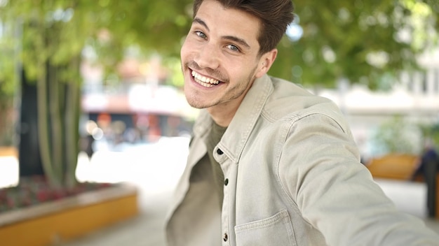 Kostenloses Foto ein junger hispanischer mann lächelt zuversichtlich und steht im park