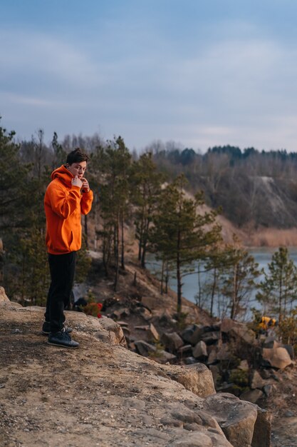 Ein junger Mann, der am Rand einer Klippe steht