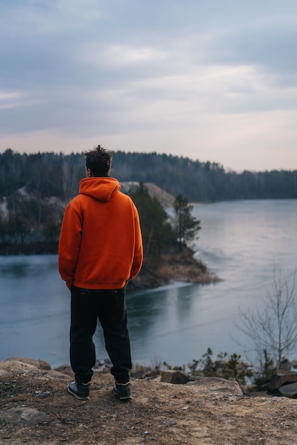 Ein junger Mann, der am Rand einer Klippe steht