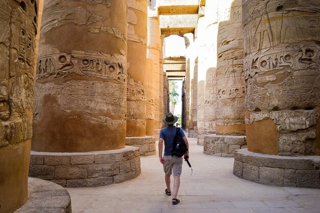 Ein junger Mann, der in einem ägyptischen Tempel spazieren geht