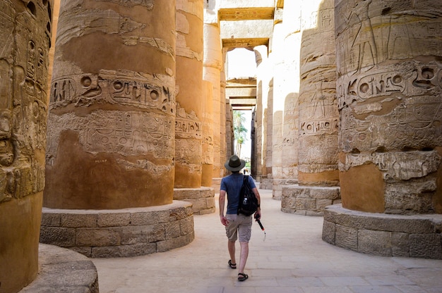 Ein junger Mann, der in einem ägyptischen Tempel spazieren geht