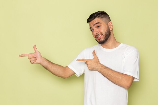 Ein junger Mann der Vorderansicht im weißen T-Shirt, das mit Lächeln aufwirft