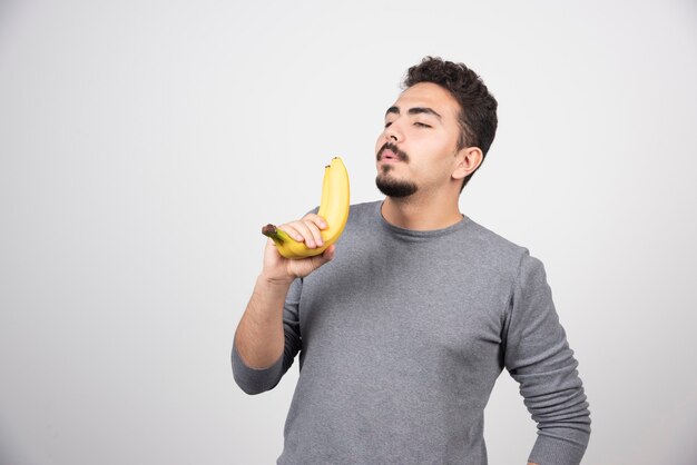 Ein junger Mann mit zwei frischen Bananen.