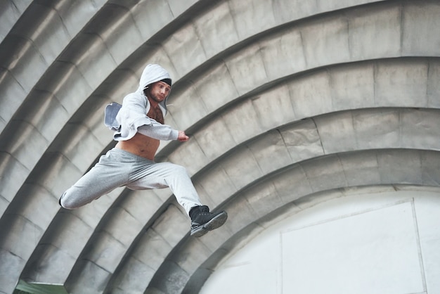 Ein junger Mann springt. Parkour im Stadtraum, sportliche Aktivität.