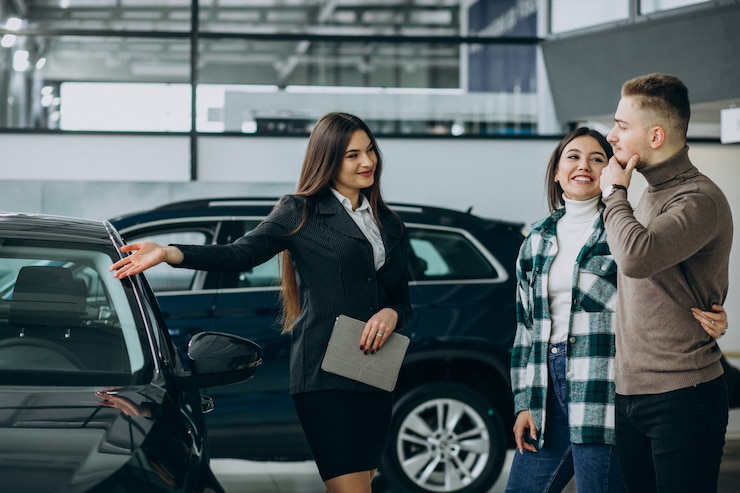 Kostenlose Foto ein junges ehepaar wählt ein auto in einem auto-show-raum aus