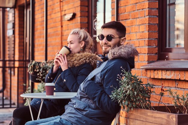 Ein junges glückliches Paar verbringt Zeit miteinander und trinkt Kaffee im Café im Freien.