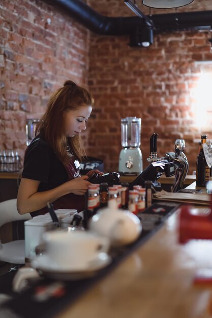 Ein junges Mädchen arbeitet in einem Café an der Bar