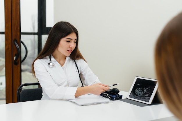 Ein junges paar bei der sprechstunde eines gynäkologen nach einem ultraschall. schwangerschaft und gesundheitsvorsorge.