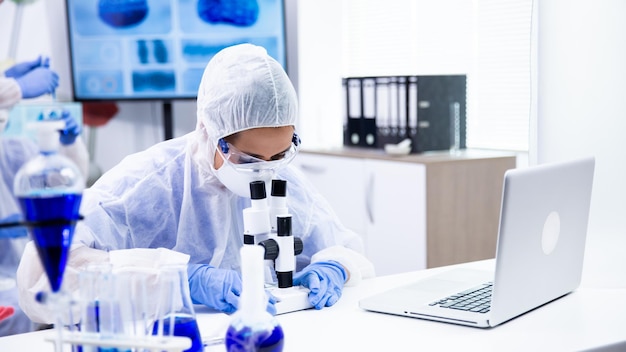 Ein kaukasischer Chemiker beobachtet eine Reaktion unter dem Mikroskop. Pharmazeutische Forschung
