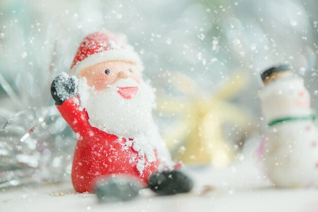 Ein keramischer Weihnachtsmann Text der frohen Weihnachten auf Schneefallhintergrund. Schöne frohe Weihnachten und guten Rutsch ins Neue Jahr 2018 auf Schneefallhintergrund.