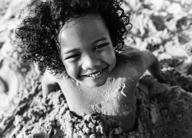 Ein kleiner Junge, der im Sand spielt