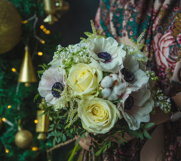 Ein kleiner weißer Rosenblumenstrauß im Weihnachten als Geschenk