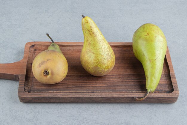 Ein kleines Holztablett mit Birnen auf Marmor