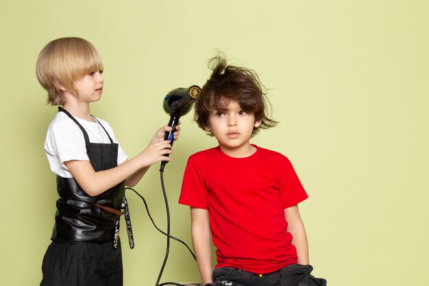 Ein kleines niedliches Friseur entzückendes Kind der Vorderansicht, das arbeitet