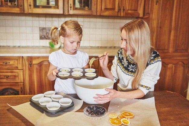 Ein kleines schönes Mädchen bereitet Cupcakes vor