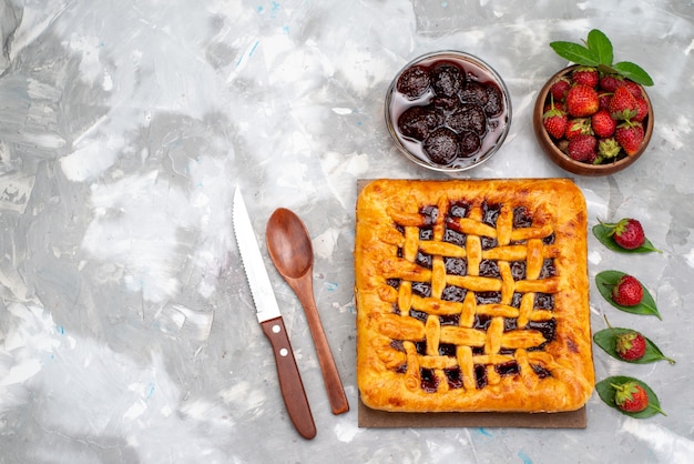 Ein köstlicher Erdbeerkuchen der Draufsicht mit Erdbeergelee nach innen zusammen mit frischem Erdbeerkuchen-Desserttee