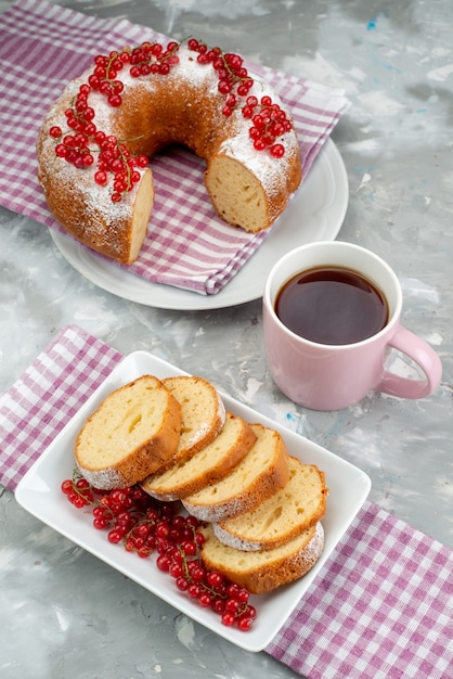 Ein köstlicher Kuchen der Draufsicht mit frischem Zimt der roten Preiselbeeren und Tee auf der weißen Schreibtischkeks-Teebeere