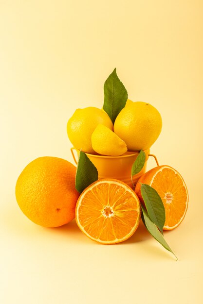 Ein Korb mit Vorderansicht mit Zitronen, die ganz frisch und saftig geschnitten wurden, zusammen mit einer Orangenscheibe auf dem cremefarbenen Hintergrund