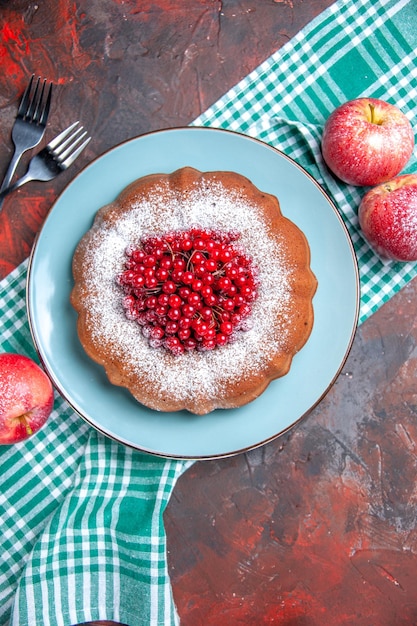 ein Kuchen ein Kuchen rote Äpfel auf der weiß-blauen Tischdecke neben den Gabeln