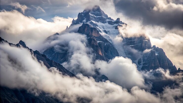 Kostenlose Foto ein majestätischer berggipfel, umhüllt von wolken