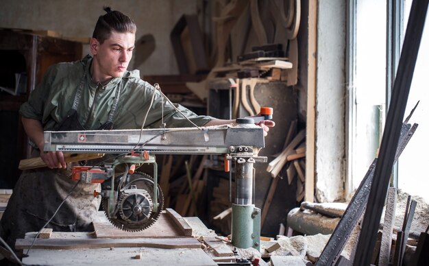 Ein Mann arbeitet an der Maschine mit dem Holzprodukt