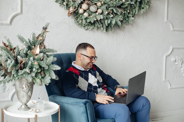 Ein mann arbeitet an heiligabend mit einem laptop zu hause