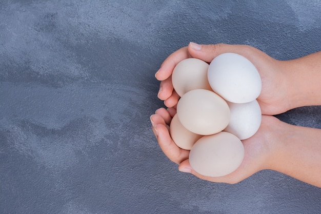 Ein Mann, der mehrere Eier in der Hand hält