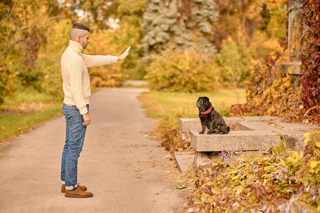 Ein Mann, der seinem Hund ein Kommando gibt