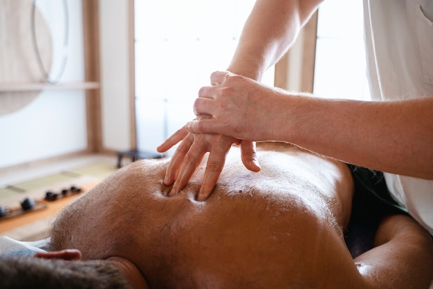 Ein Mann mit einem hohen Winkel, der Massage bekommt