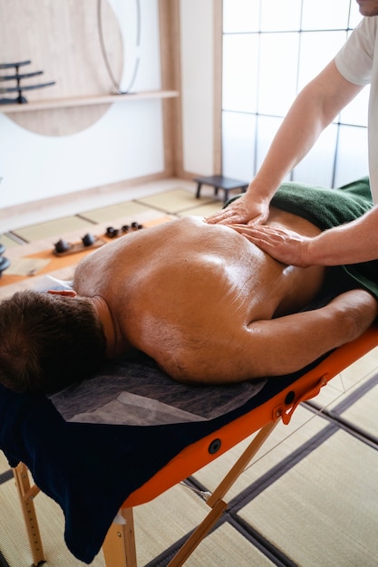 Ein Mann mit einem hohen Winkel, der Massage bekommt