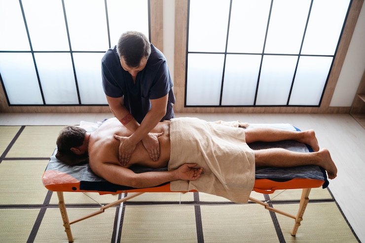 Kostenlose Foto ein mann mit einem hohen winkel, der massage bekommt