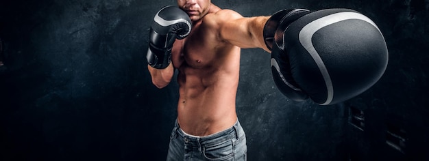 Ein Mann mit einem wunderschön muskulösen Körper ist bereit für den Kampf und bläst seine spektakulären Schläge.