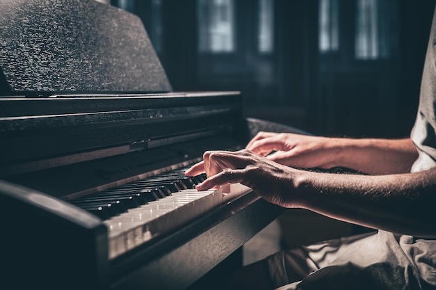 Ein Mann spielt in einem dunklen Raum ein elektronisches Klavier