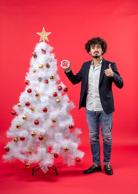 Ein Mann steht neben dem Weihnachtsbaum